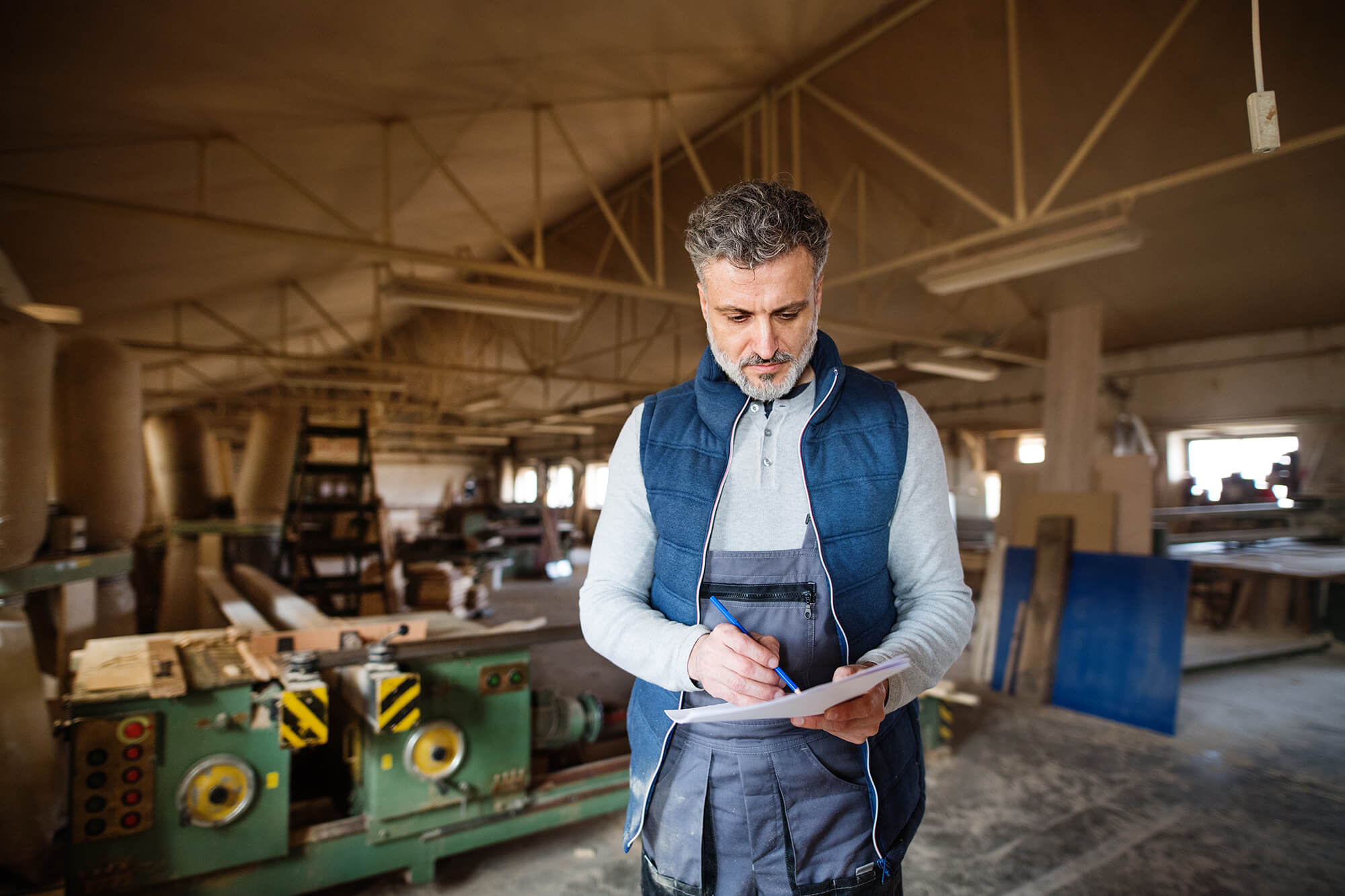 A man worker in the carpentry workshop, making plans